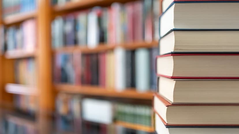Stapel juristischer Fachbücher vor einem Bücherregal