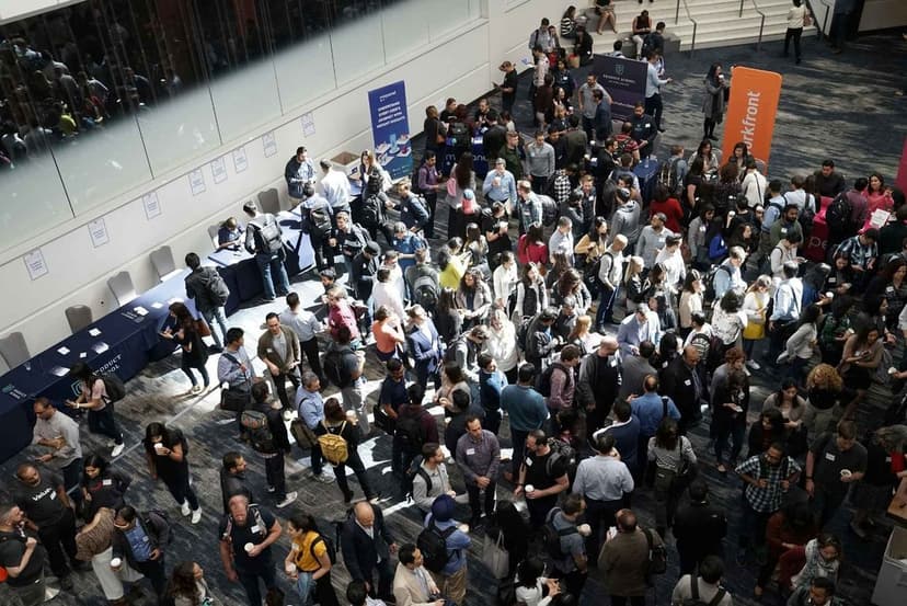 Rechtsanwälte netzwerken auf einer juristischen Fachkonferenz mit Messeständen im Hintergrund